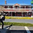 Rob Roy Hotel in Waihi, New Zealand with statue of kids having fun - Woodward Culture